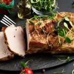 Baked piece of pork balyk on the table with spices