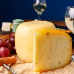 Head of cheese on brown wooden table close up
