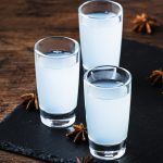 Ouzo - Greek anise brandy, traditional strong alcoholic drink in glasses on the old wooden table, place for text